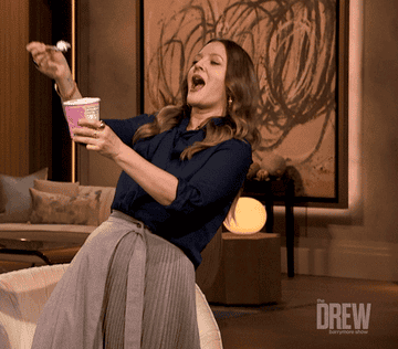 Drew Barrymore dancing and eating a big spoonful of ice cream