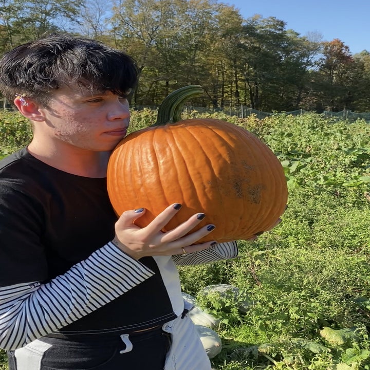 Harper wearing the half black half white shirt in a pumpkin patch