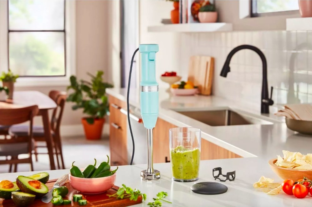 Hand blender in color &quot;Ice Blue&quot; on a kitchen counter with various ingredients