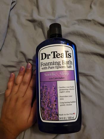 A reviewer showing a size comparison with her hand and the product bottle