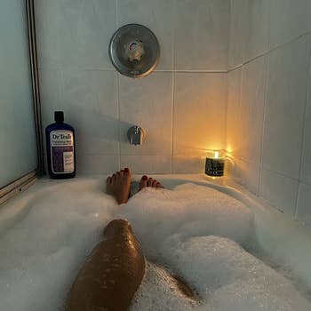 A reviewer showing their feet in a bubble bath