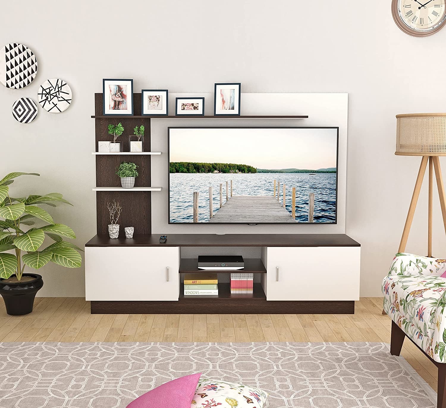 A white TV unit with a TV and other home decor items in it