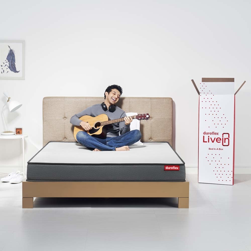 A memory foam mattress on a bed with a man singing with a guitar