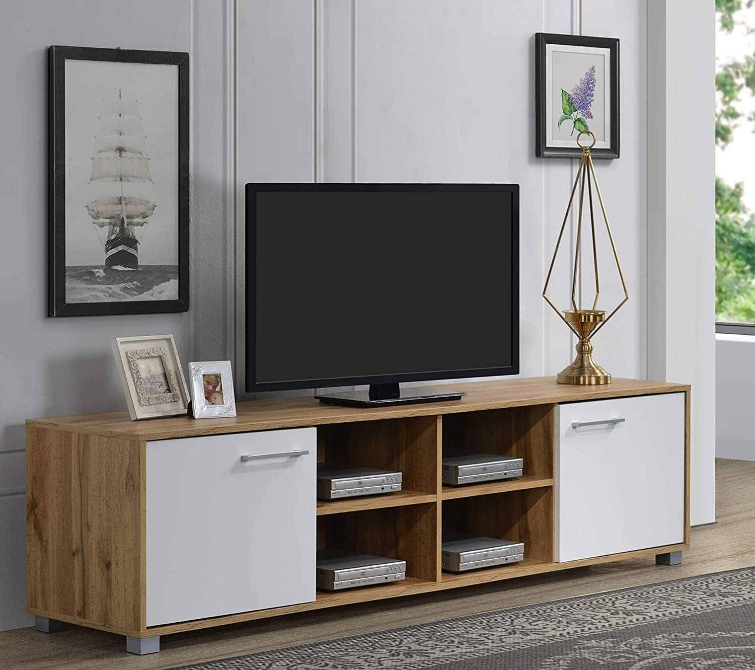 A TV unit with set top boxes, photos and a TV in it