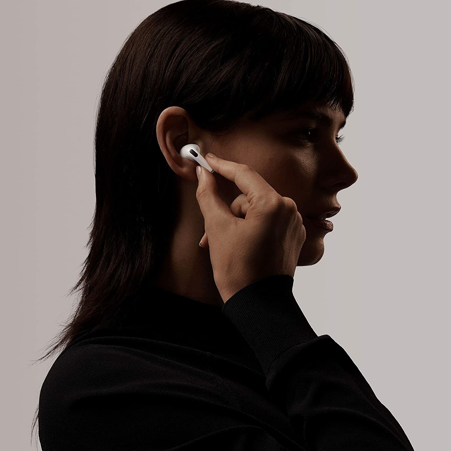 A woman putting the earbud in her ear
