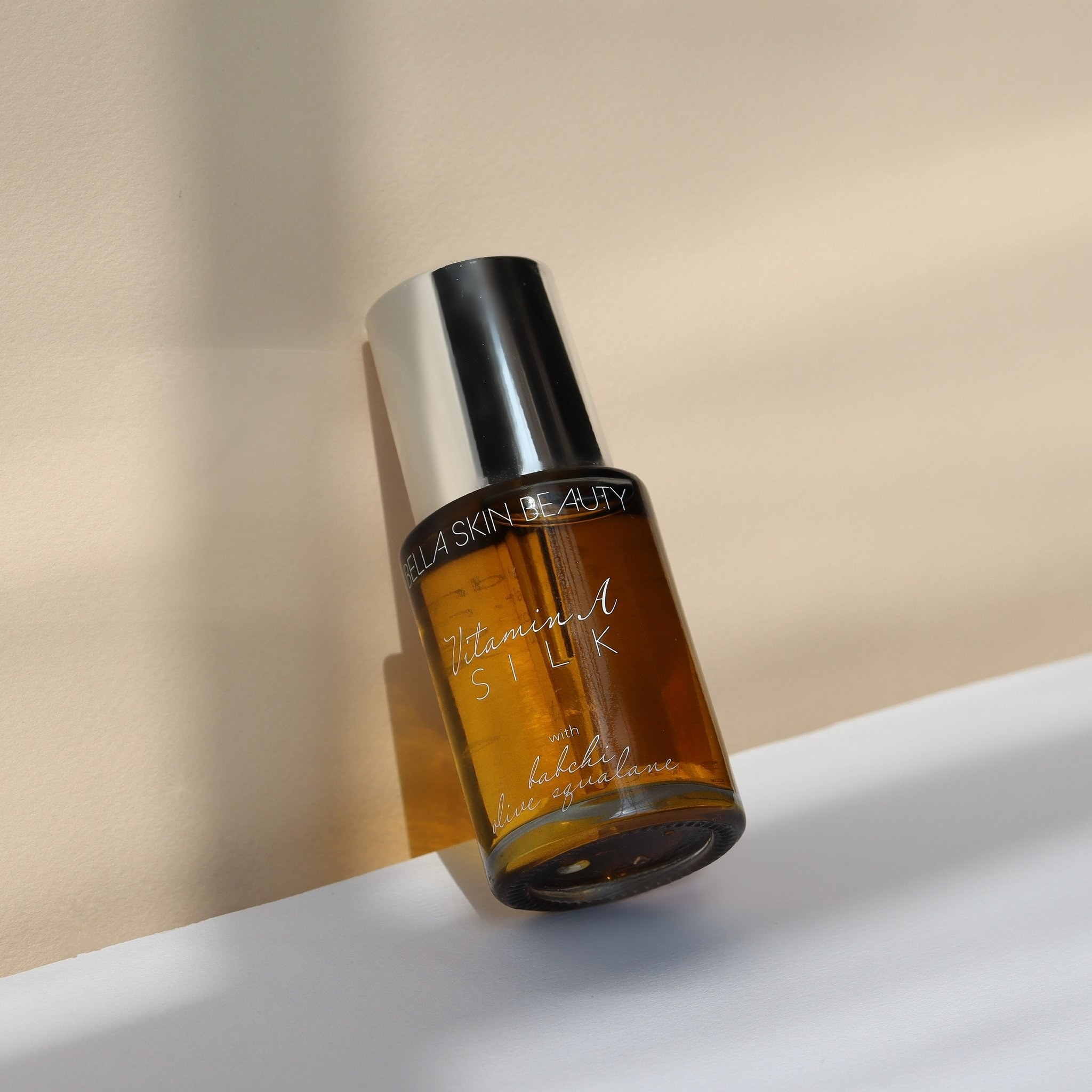 The Vitamin A Silk Night Face Oil bottle leaning against a wall for display
