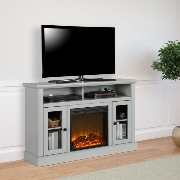 The gray TV console with an electric artificial fireplace.