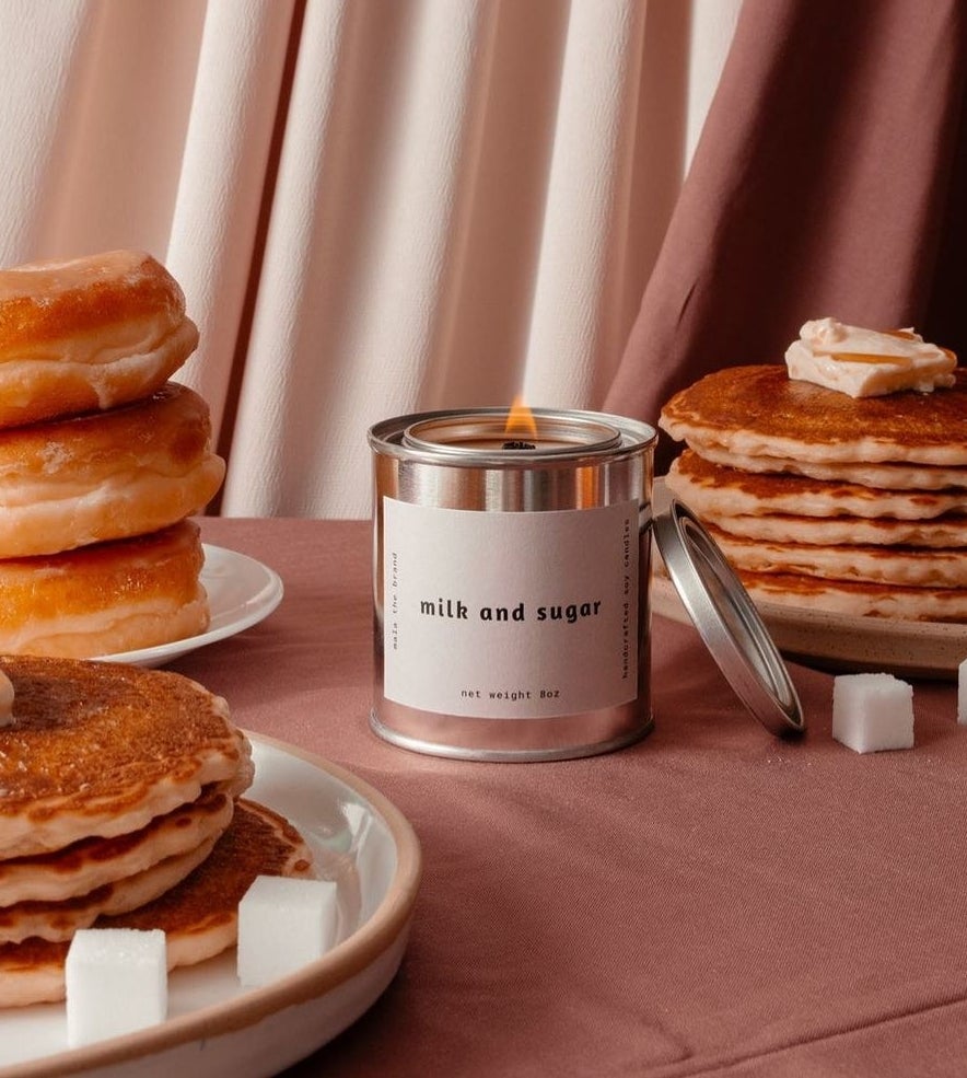 A milk and sugar candle surrounded by donuts and pancakes