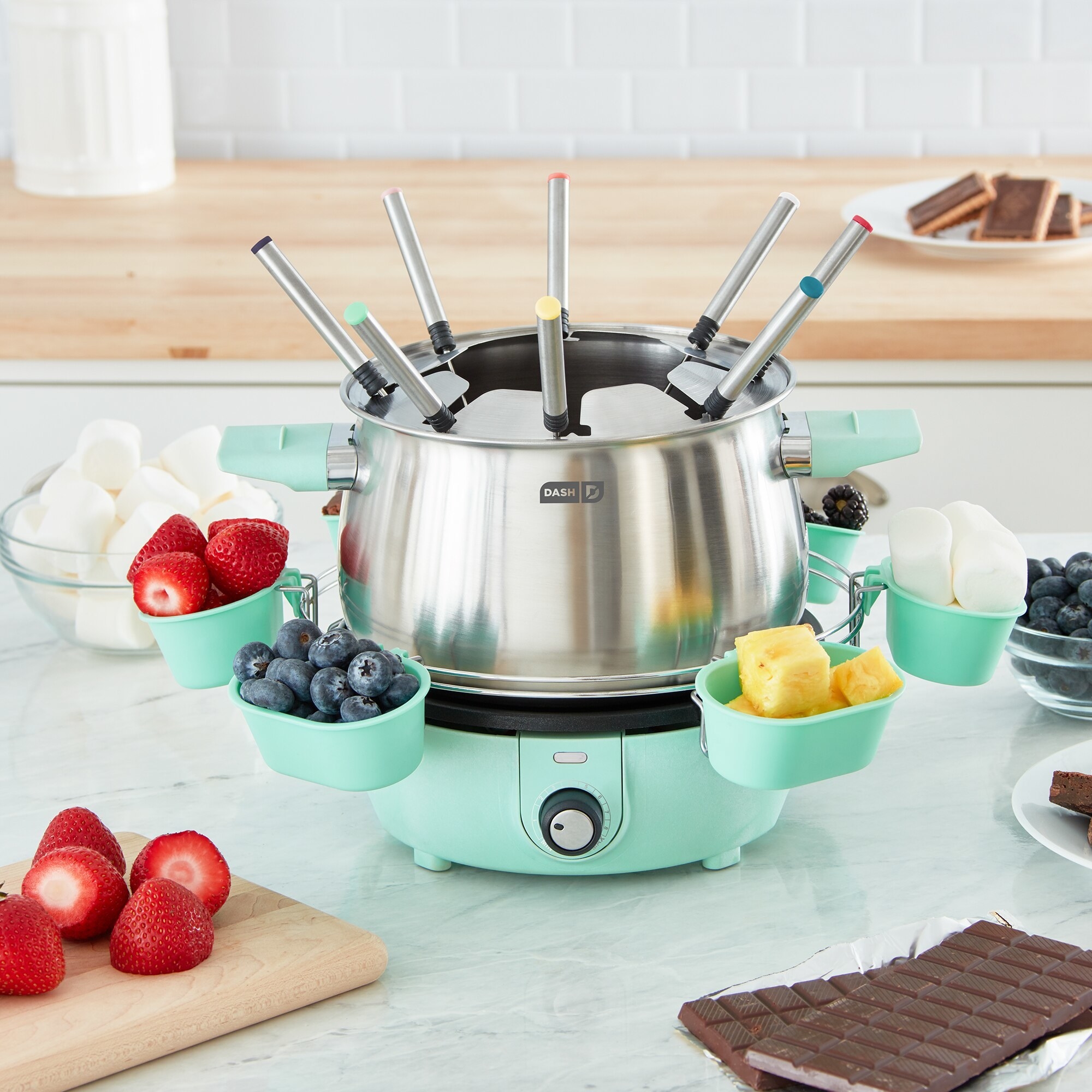 The fondue maker with fruit and marshmallows in its bowls