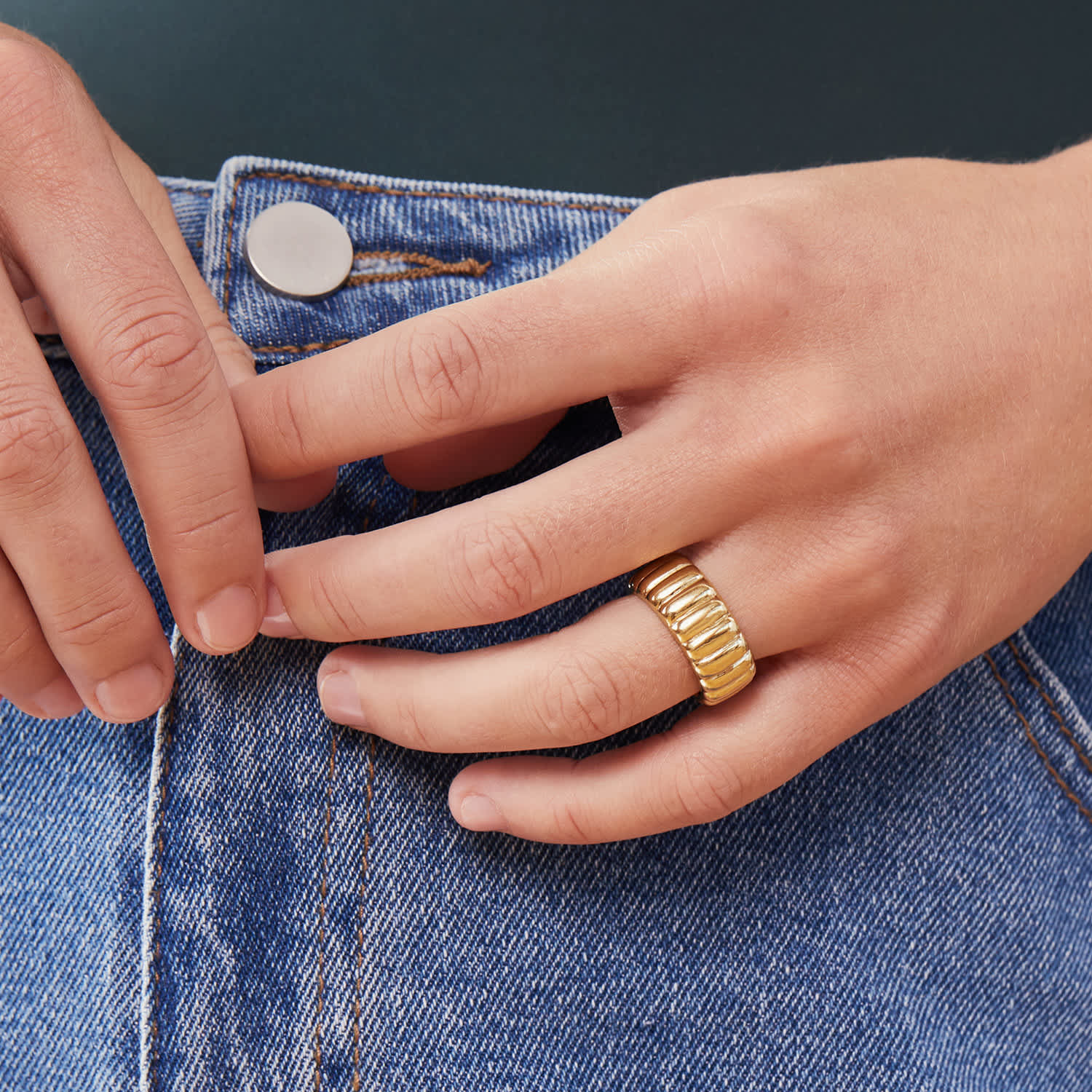 A person wearing the ring while holding their hands in front of their jeans