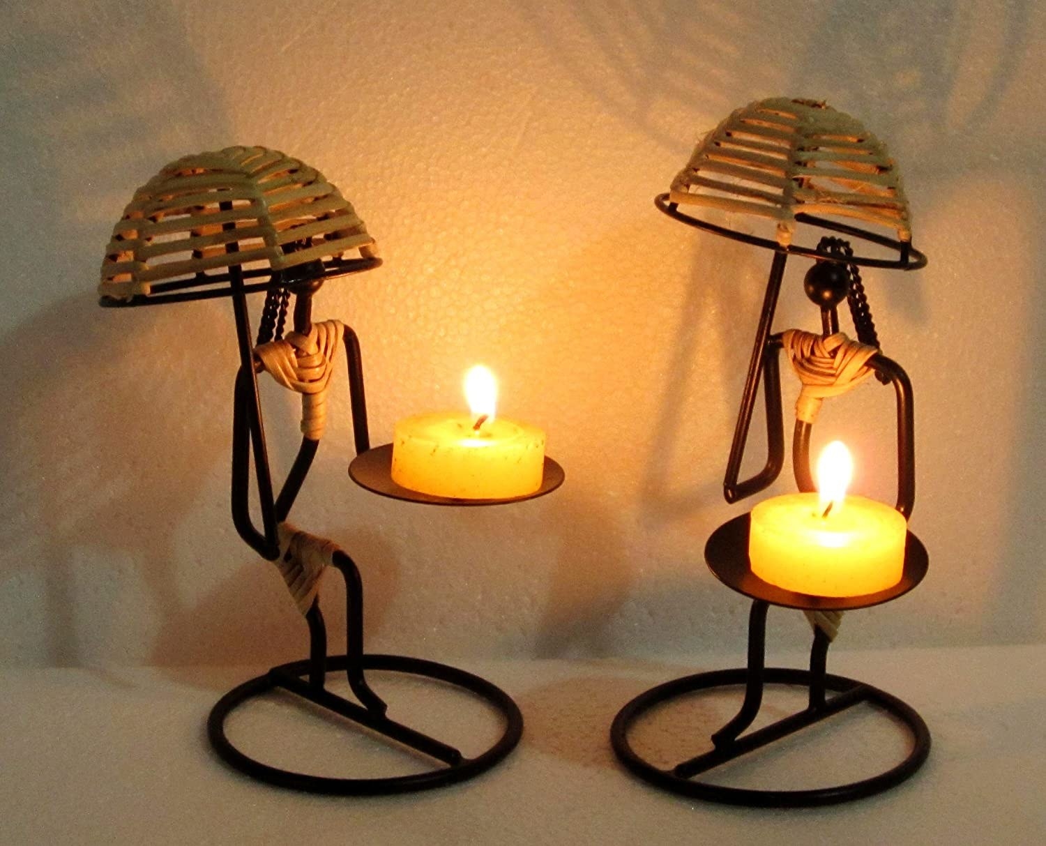 Two women-shaped candle holders holding a candle