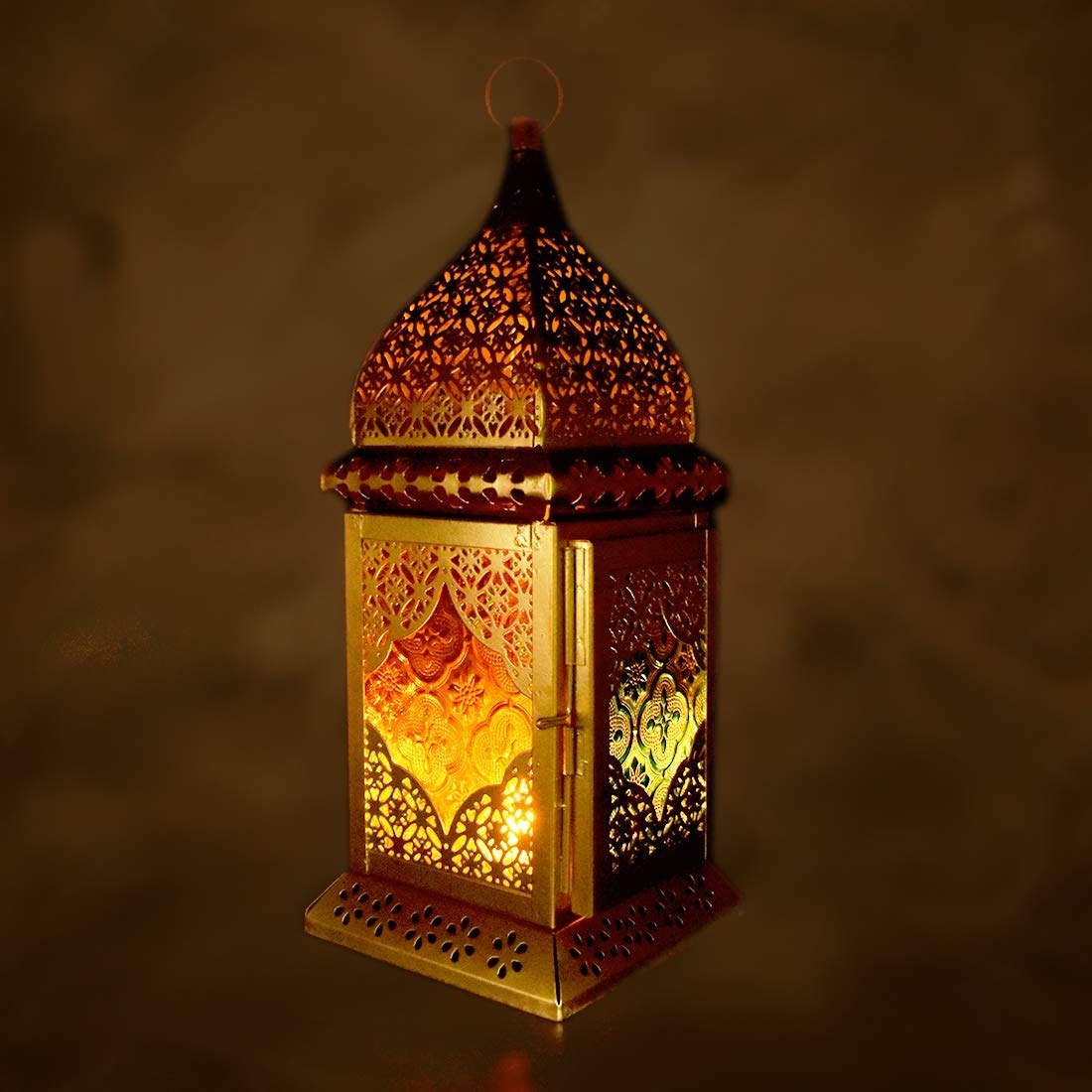 A brass hanging lamp with a tealight in it