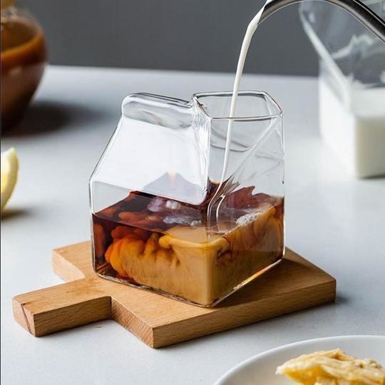 a short glass shaped like an open milk carton