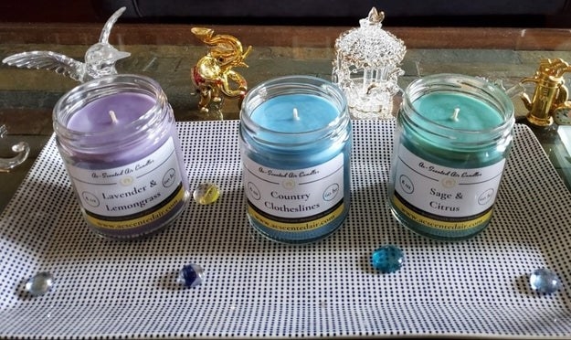 three glass candles in purple, blue, and green