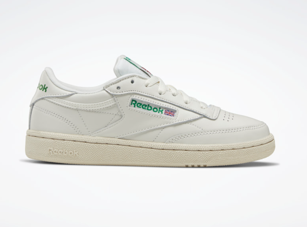 a white sneaker with the reebok logo in green