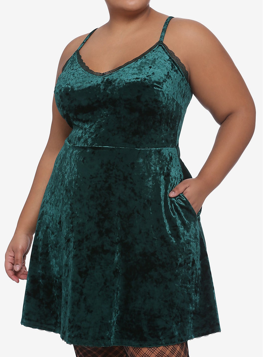 model in emerald mini dress with hand in one of the pockets