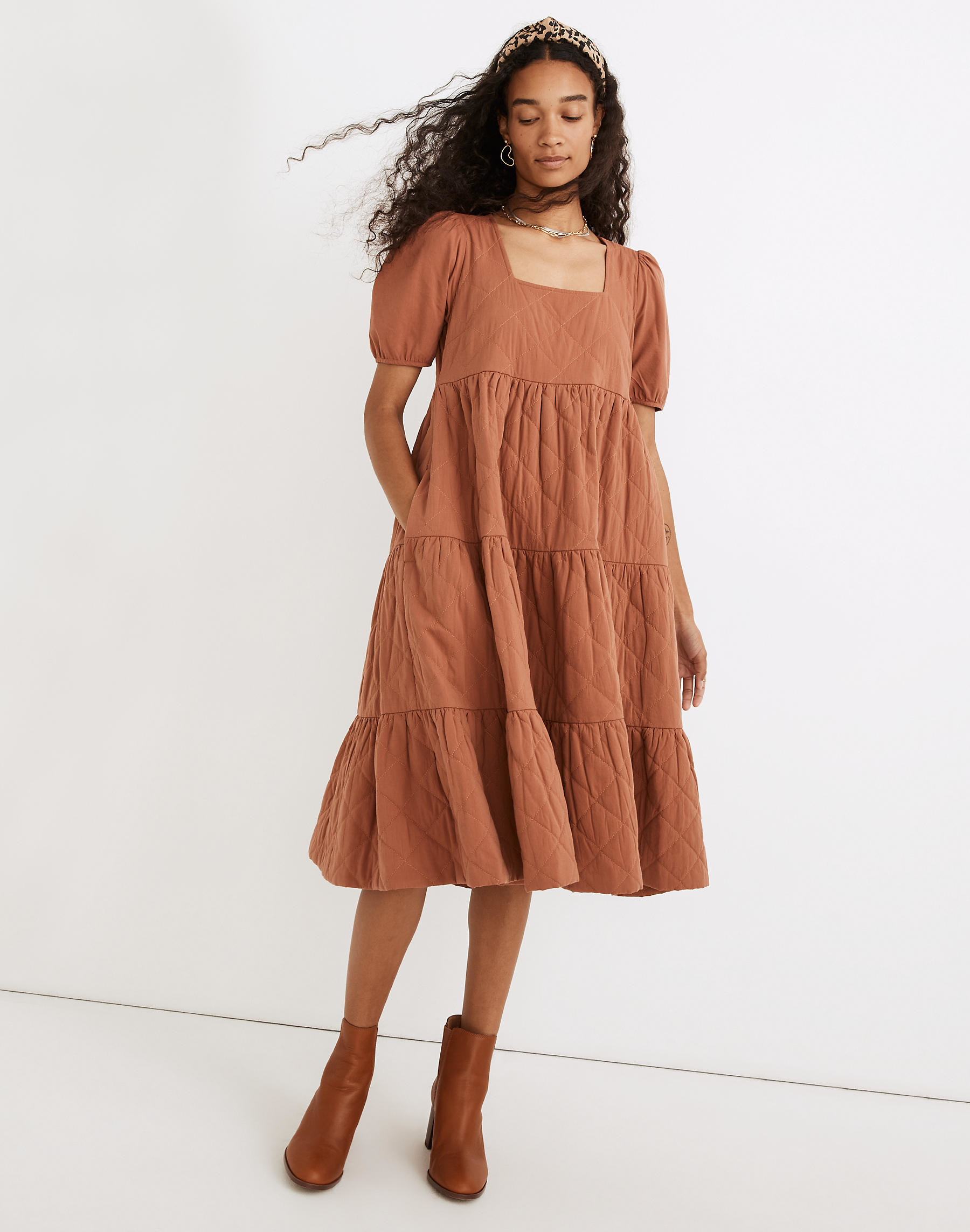 model in burnt orange short sleeve square neck dress with hand in one of the pockets