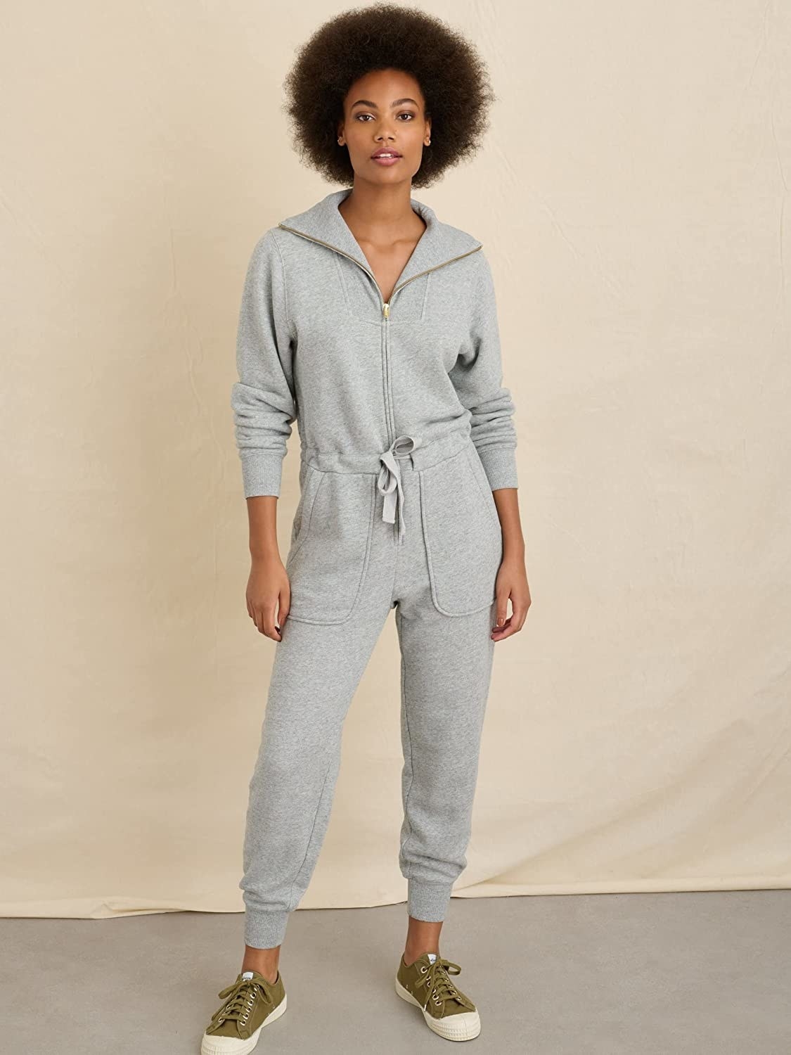 A model in the grey jumpsuit with drawstring waist and side pockets