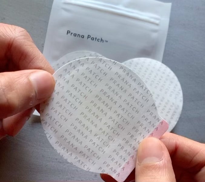a person peeling off the backing of the cotton aromatherapy patch
