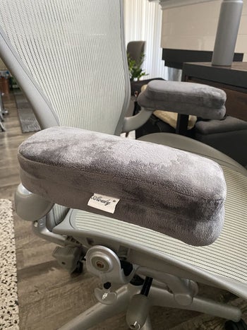 a close up photo of the armrest pads on an office chair in gray