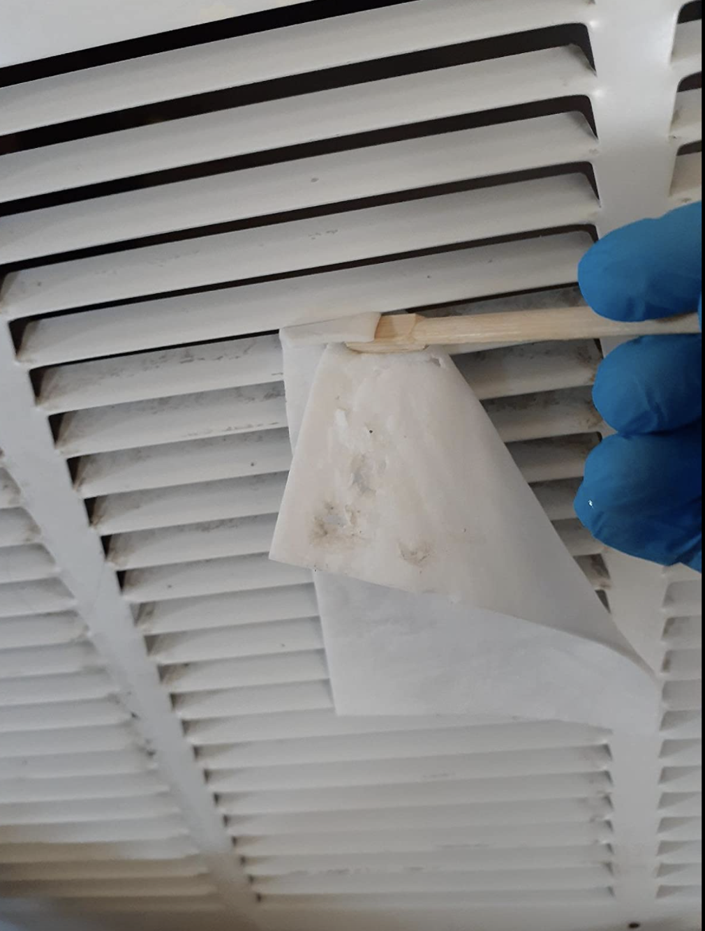 Reviewer using the sheet to clean an air conditioning grate