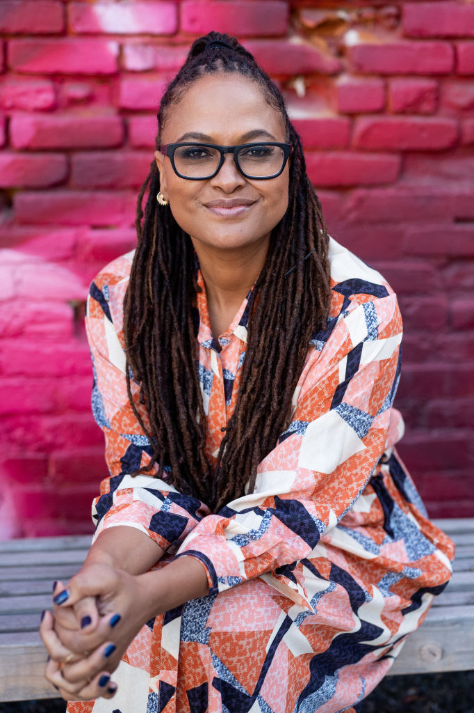 Ava DuVernay sitting on a table