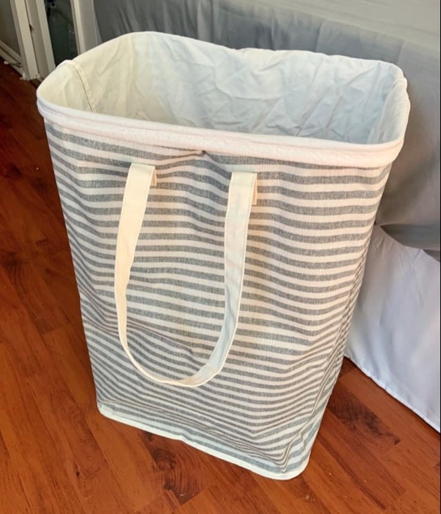 A grey and white striped hamper in a reviewer&#x27;s bedroom
