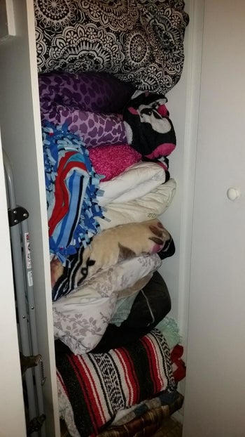 Reviewer's before picture of messy closet filled with blankets and towels