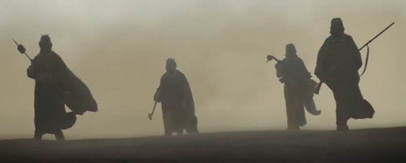 Tusken Raiders walk in a sandstorm