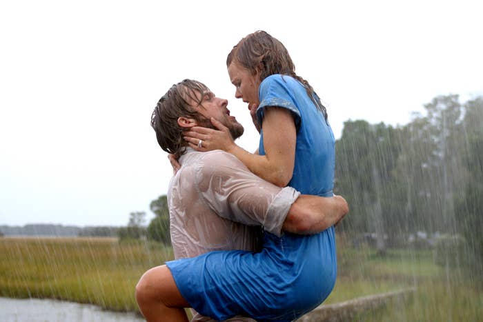 A couple embraces passionately in the rain, with lush greenery in the background, reminiscent of a dramatic movie scene