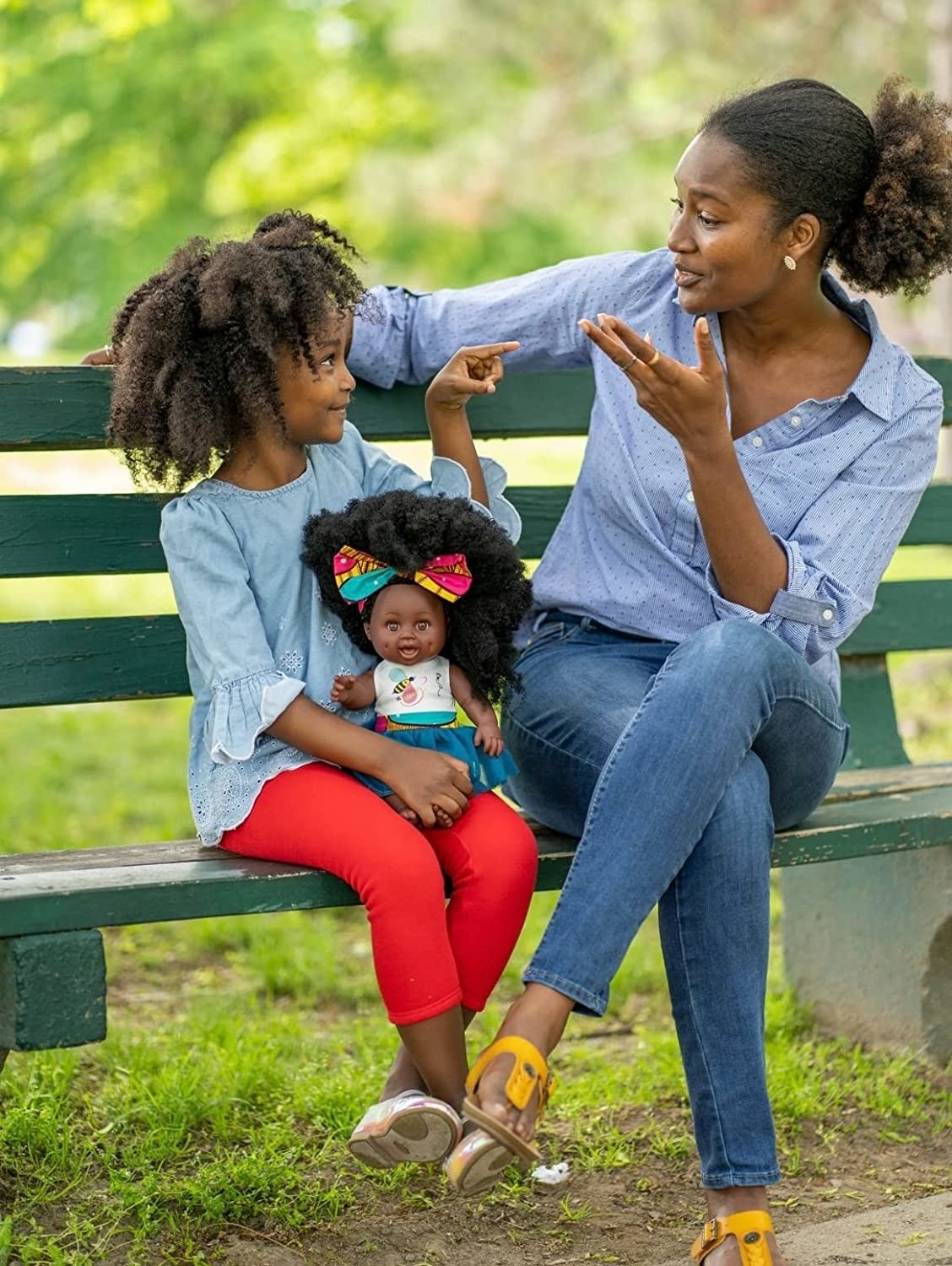 A parent and child holding the doll with a curly fro