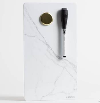 The white marble dry erase board with a magnetized pen and extra magnet