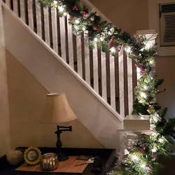 Reviewer photo of the lit garland lining their staircase at night