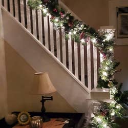 Reviewer photo of the lit garland lining their staircase at night