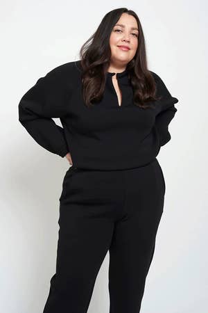 A model in the black notch-neck pullover