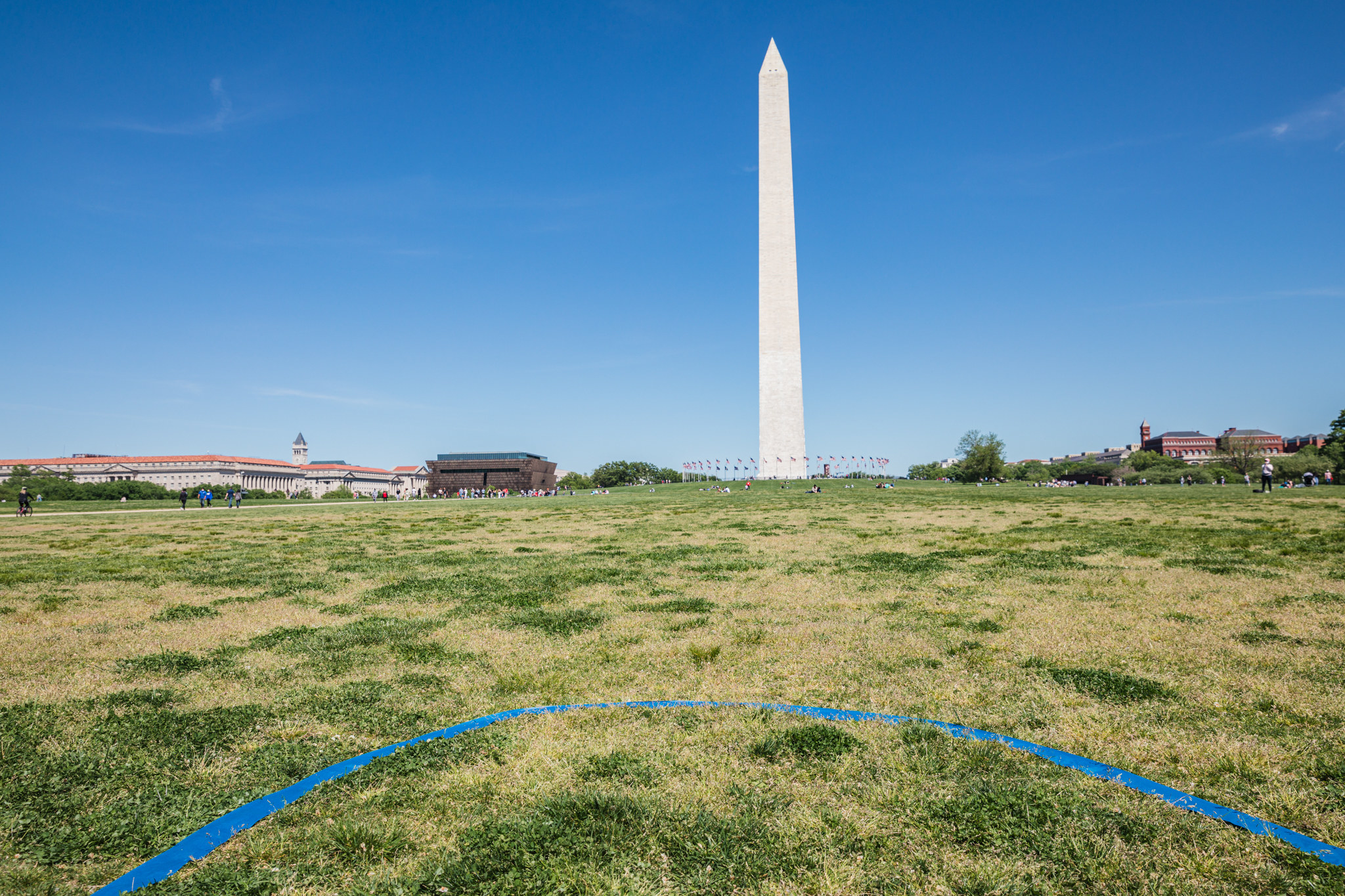 The Washington Monument in the distance, with a blue tape on its nearby grass