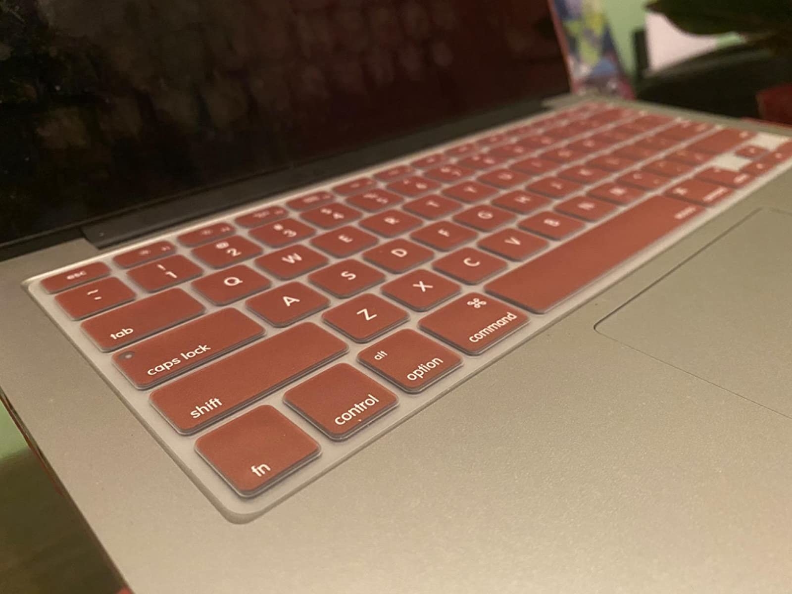 a closeup of the keyboard cover in a rusty pink on a laptop keyboard