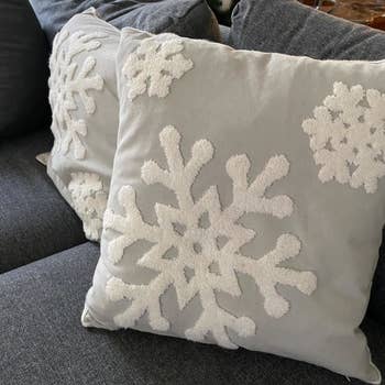 Reviewer photo of a pair of pillows inside the gray snowflake pillow covers