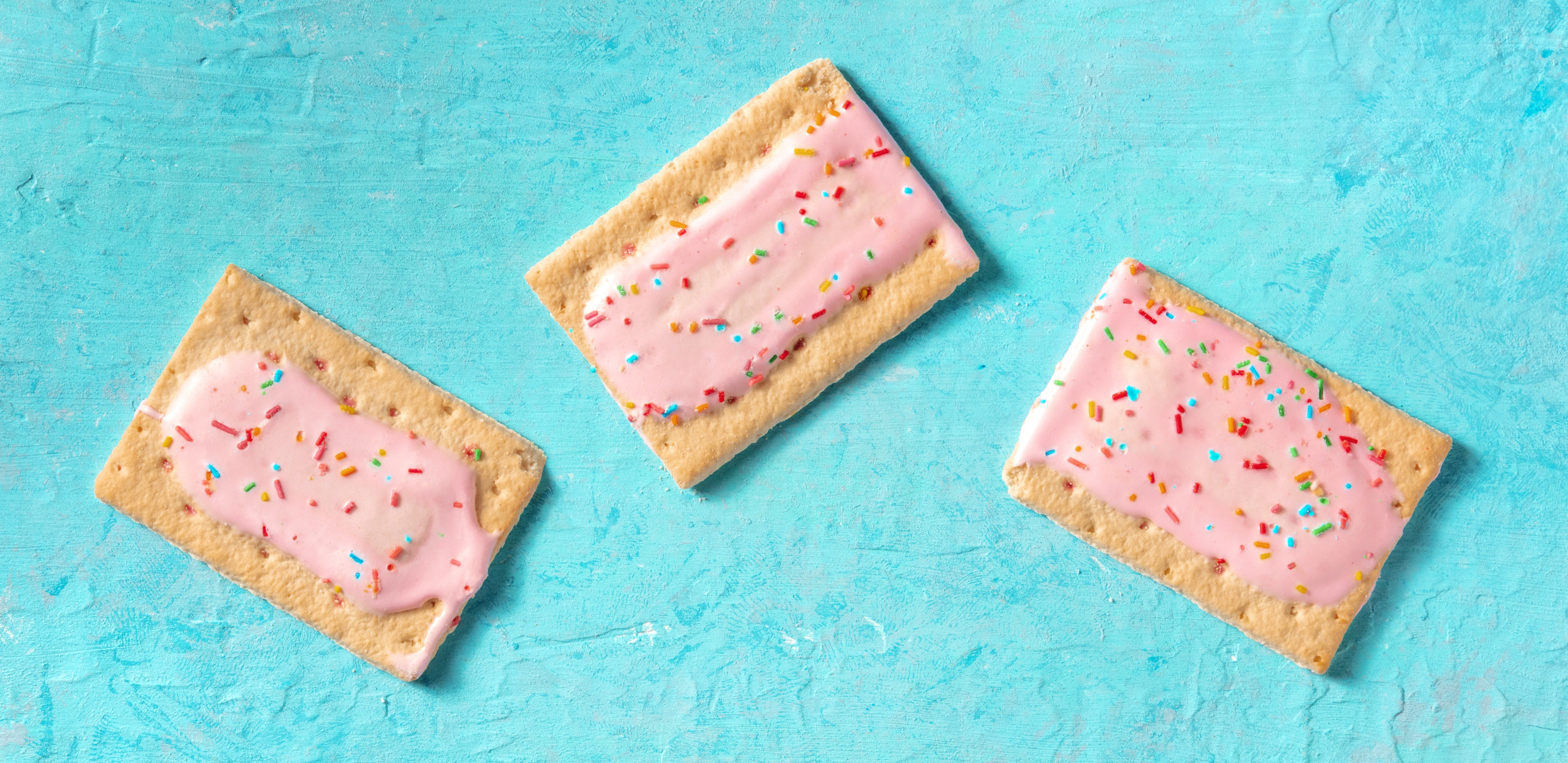 Three strawberry Pop-Tarts with sprinkles.