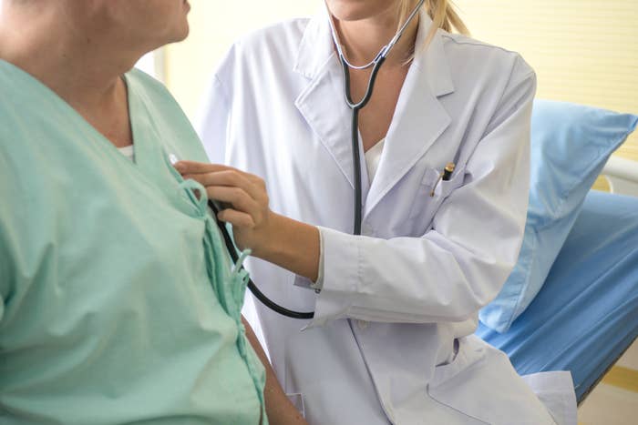A doctor using a stethoscope to check a patient