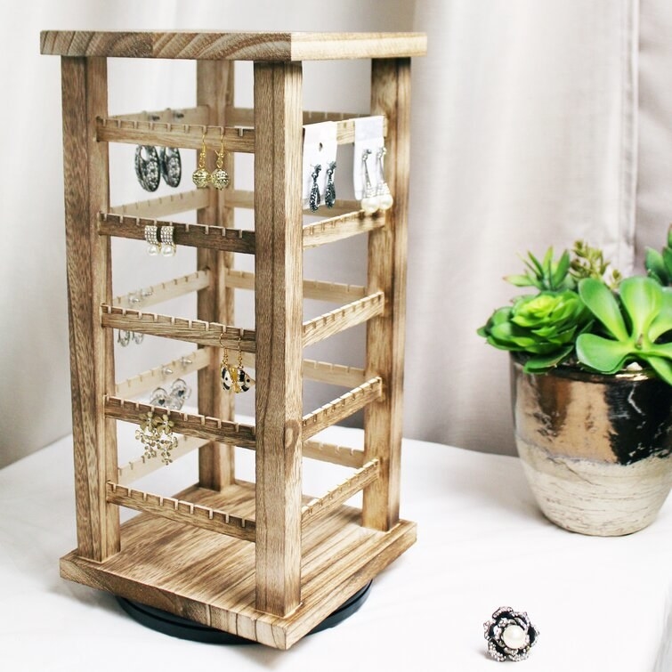a four-sided wooden earring organizer tower on a rotating base