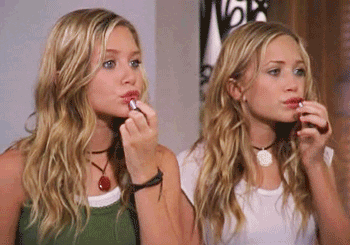 Mary-Kate and Ashley stand in the mirror applying lipstick and pouting