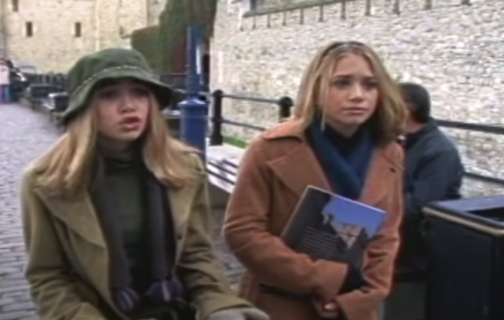Mary-Kate and Ashley walking down a cobblestone street as Chloe and Riley