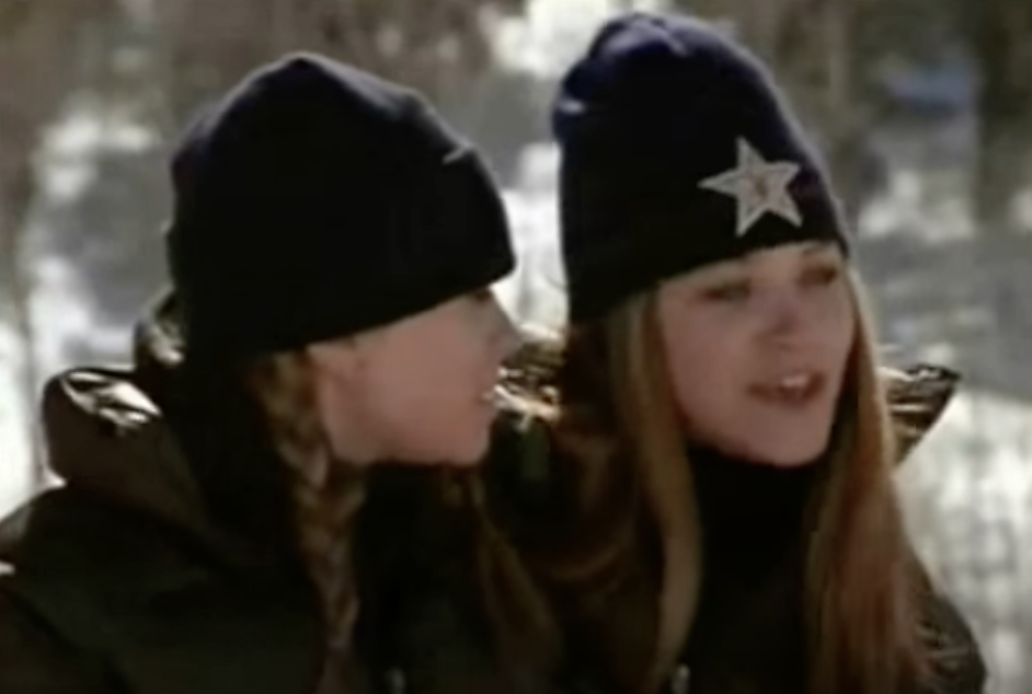 Mary-Kate and Ashley standing on a snowy hill wearing beanies and puffy jackets as Kylie and Taylor