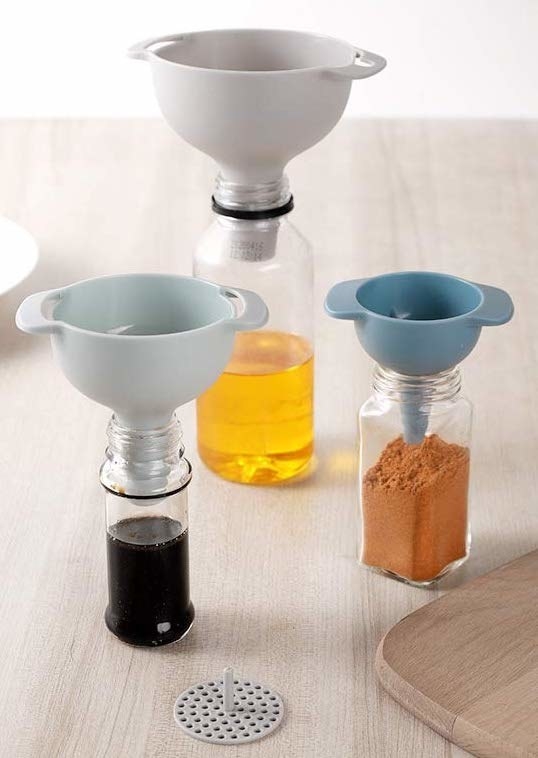 a set of three nesting funnels inserted into three different spice bottles