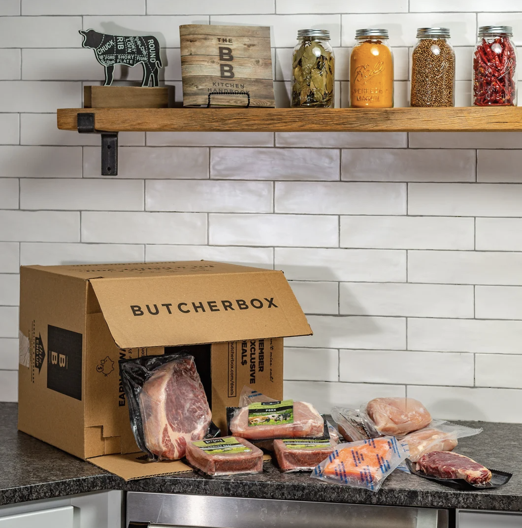 a box with various packaged meats spilling out of it onto a counter