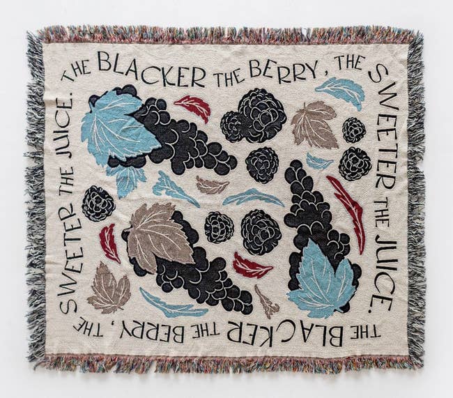 a blanket with blackberries and leaves on it with a boarder that says 