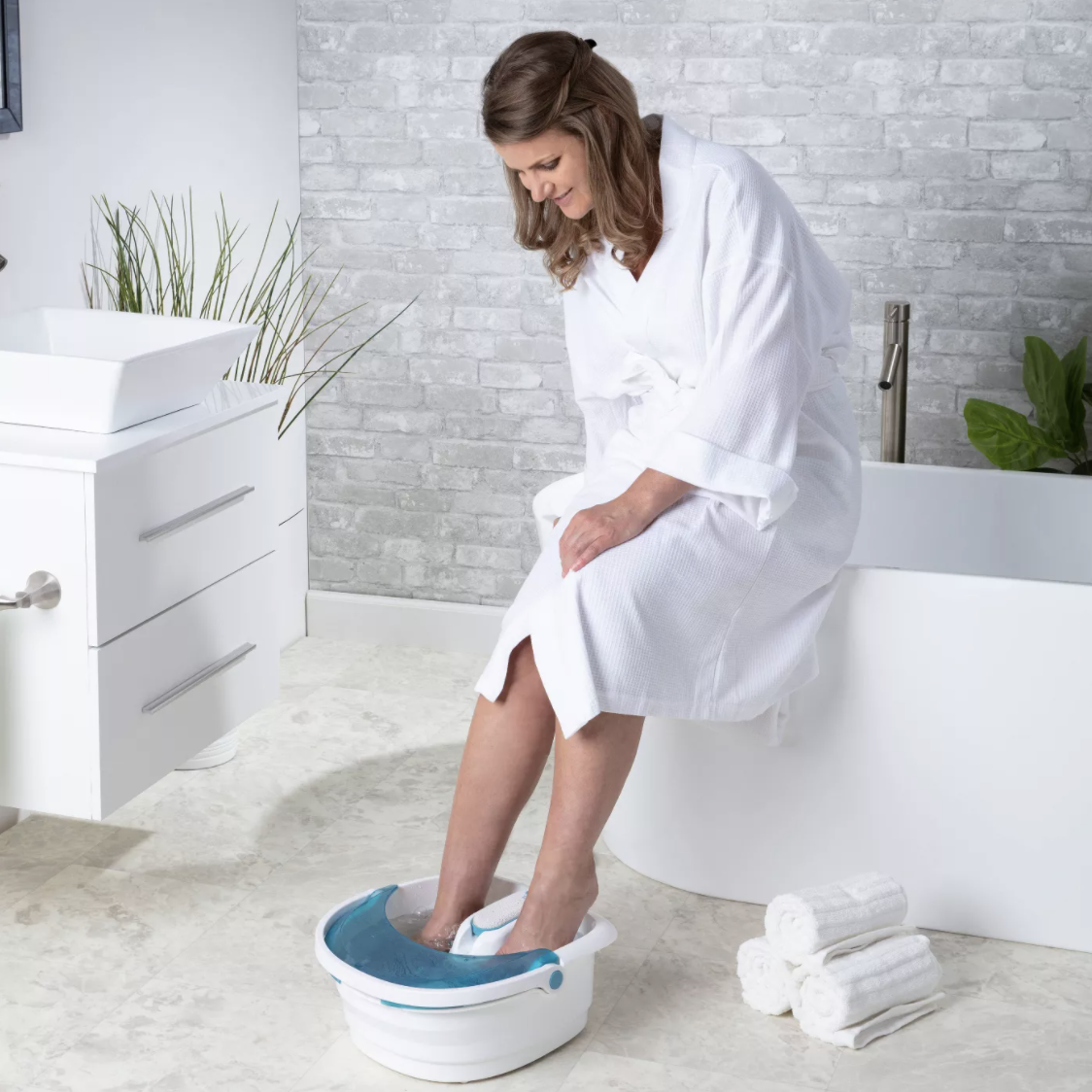 model places feet into white and blue foot bath