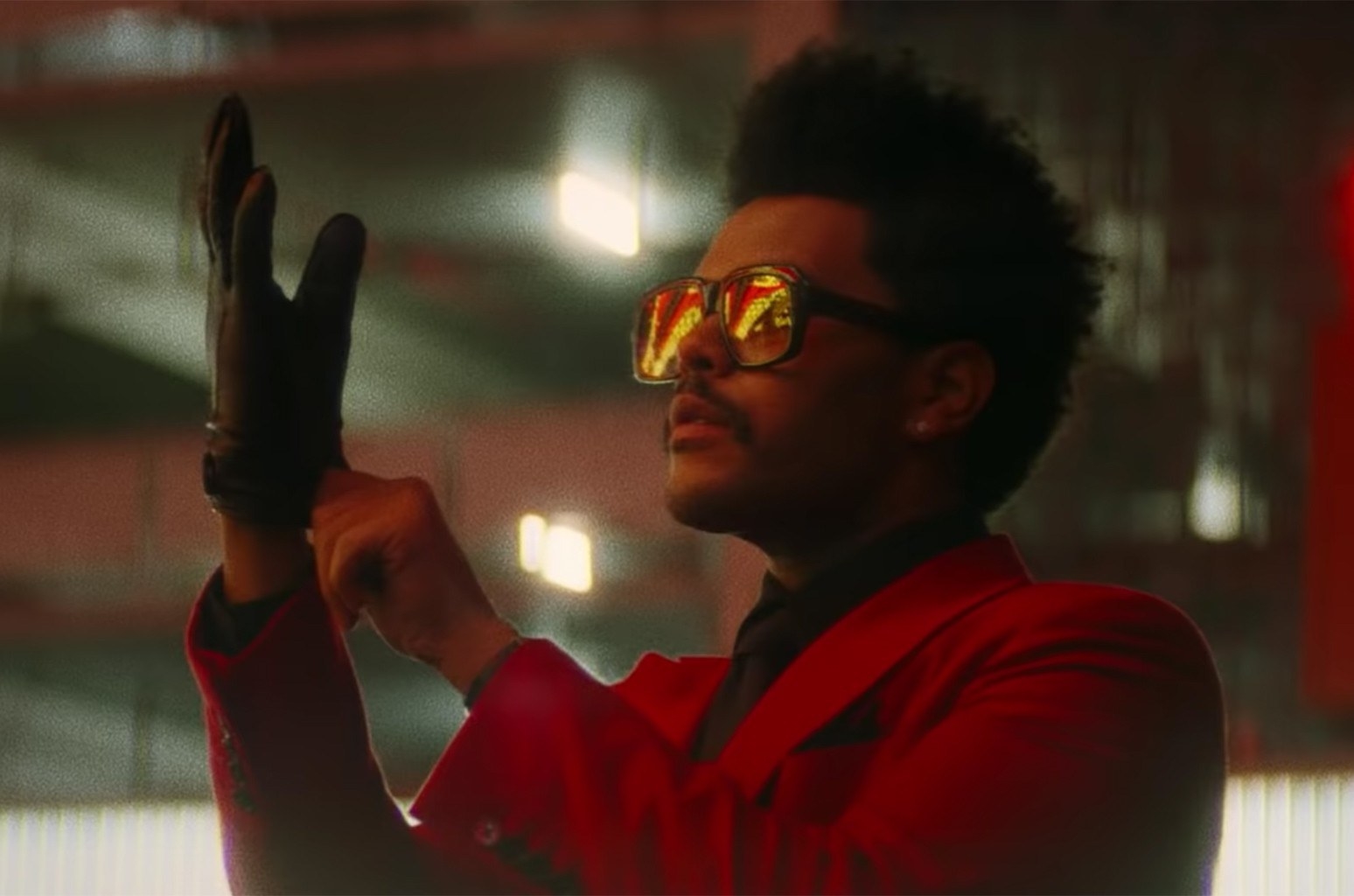 The Weeknd putting on a glove in the Blinding Lights music video