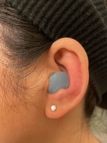 reviewer wearing a blue ear plug